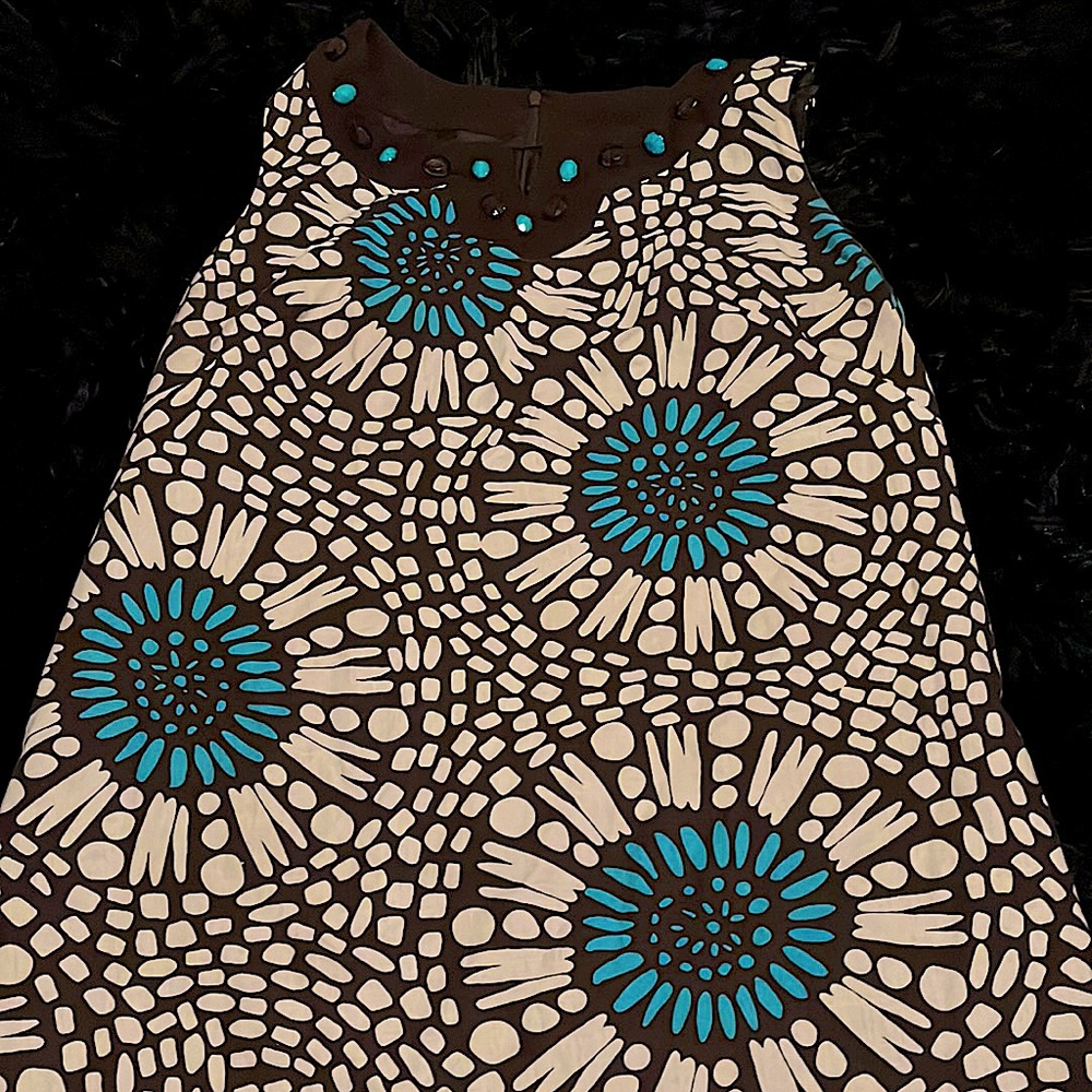 A brown and white flower dress with blue turquoise as a accent color